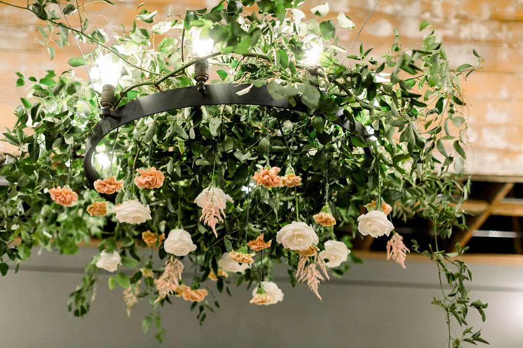 A gorgeous chandelier over the head table filled with roses and greenery filled Abby + Justin’s reception with sweet floral perfume!