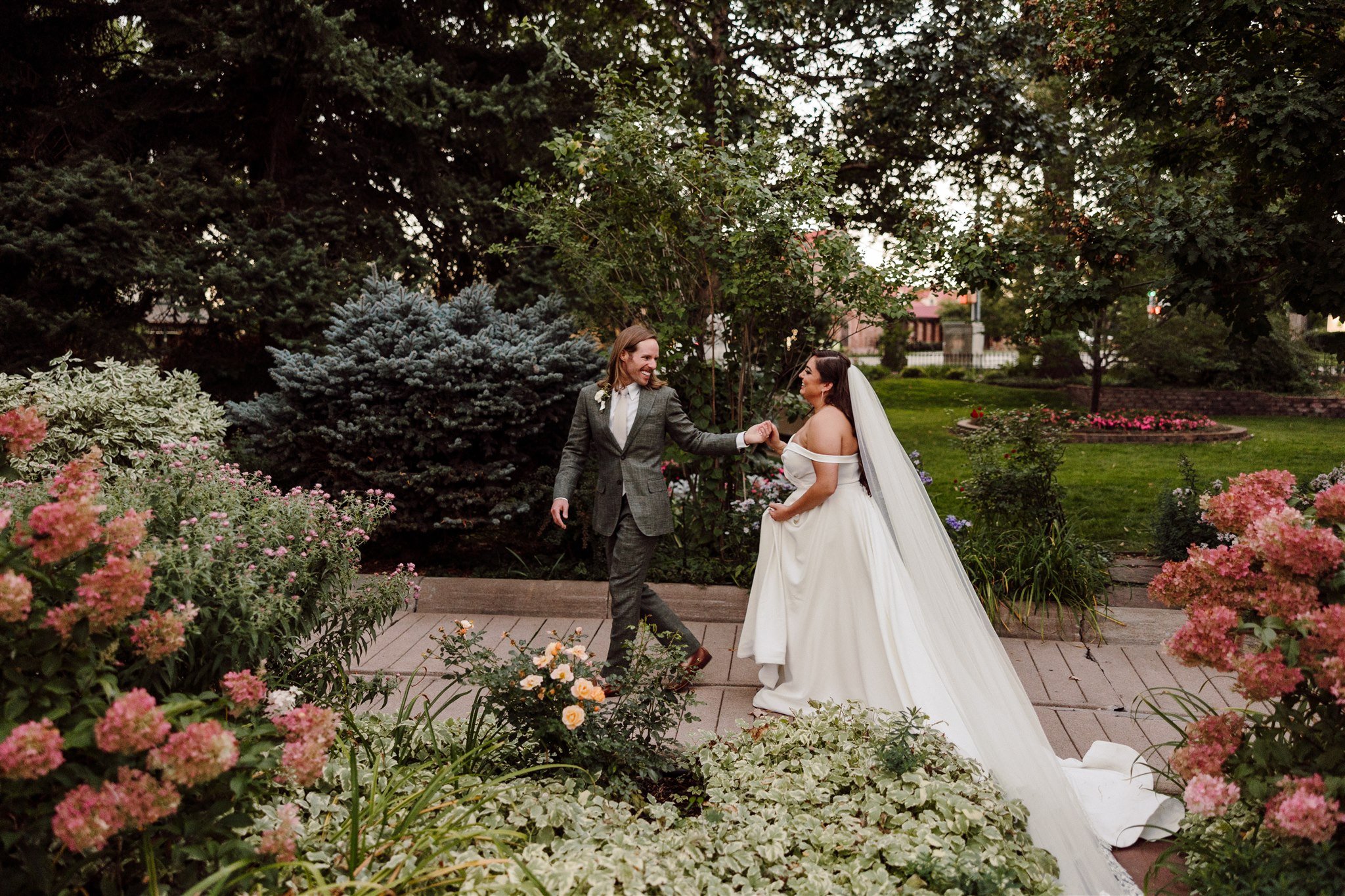 Bride and groom walking through gardens at wedding at Longmont Colorado