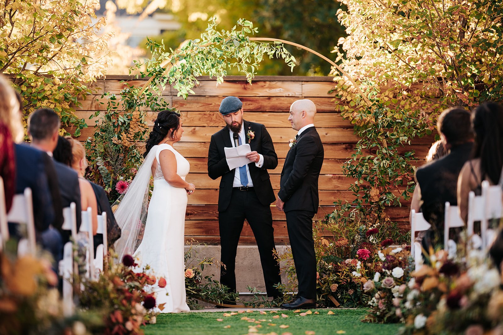 Couple getting married in front of circular arch in courtyard of the St Vrain wedding venue, Colorado