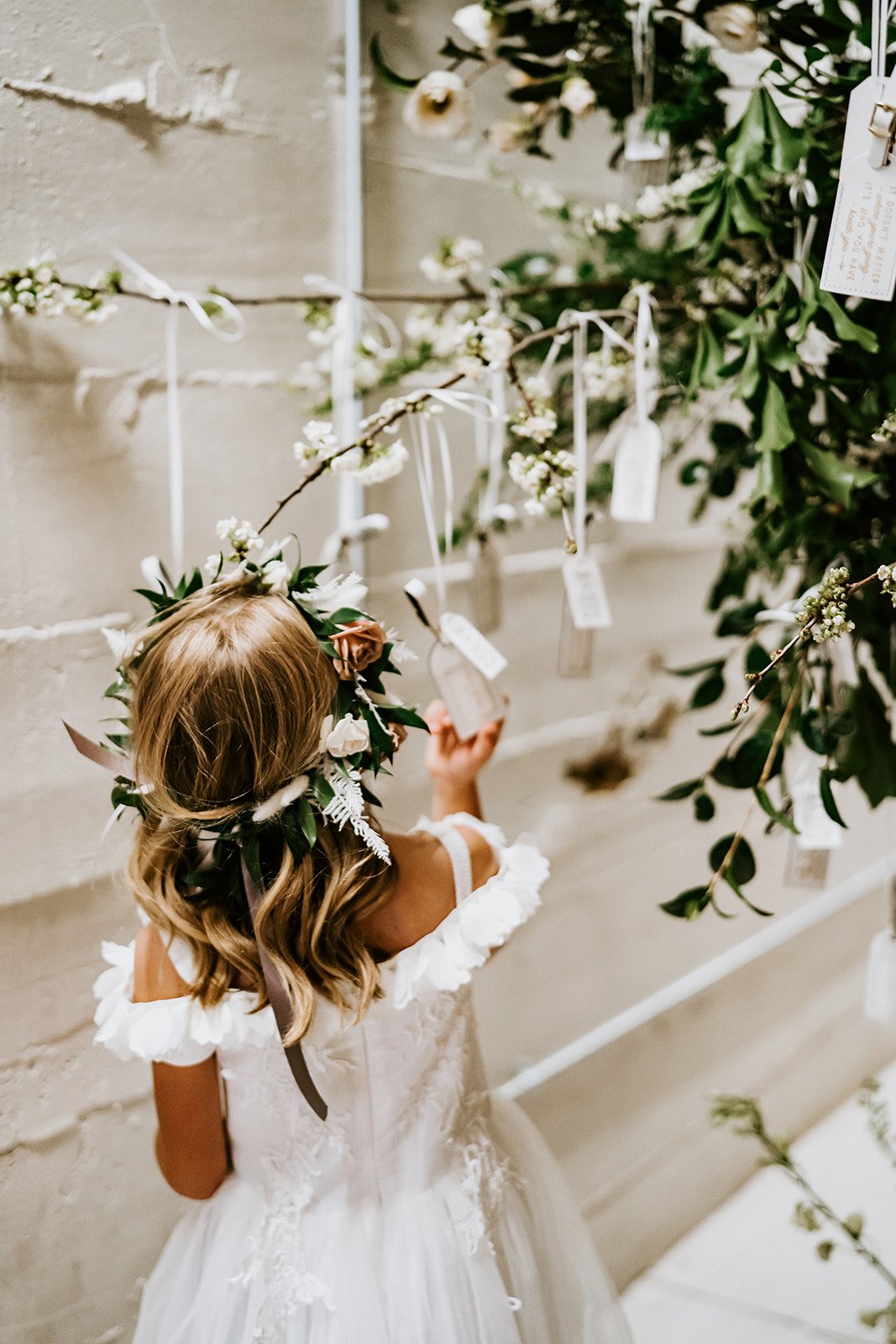 Luggage tags as wedding favor and escort card idea. Little girl picking out a luggage tag at St Vrain wedding venue in Boulder County.